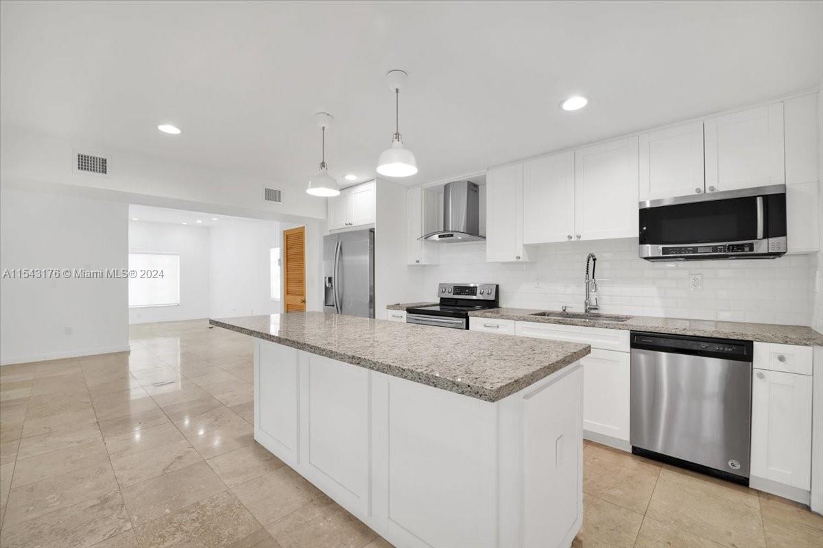 a kitchen with granite countertop a sink a counter top space appliances and cabinets