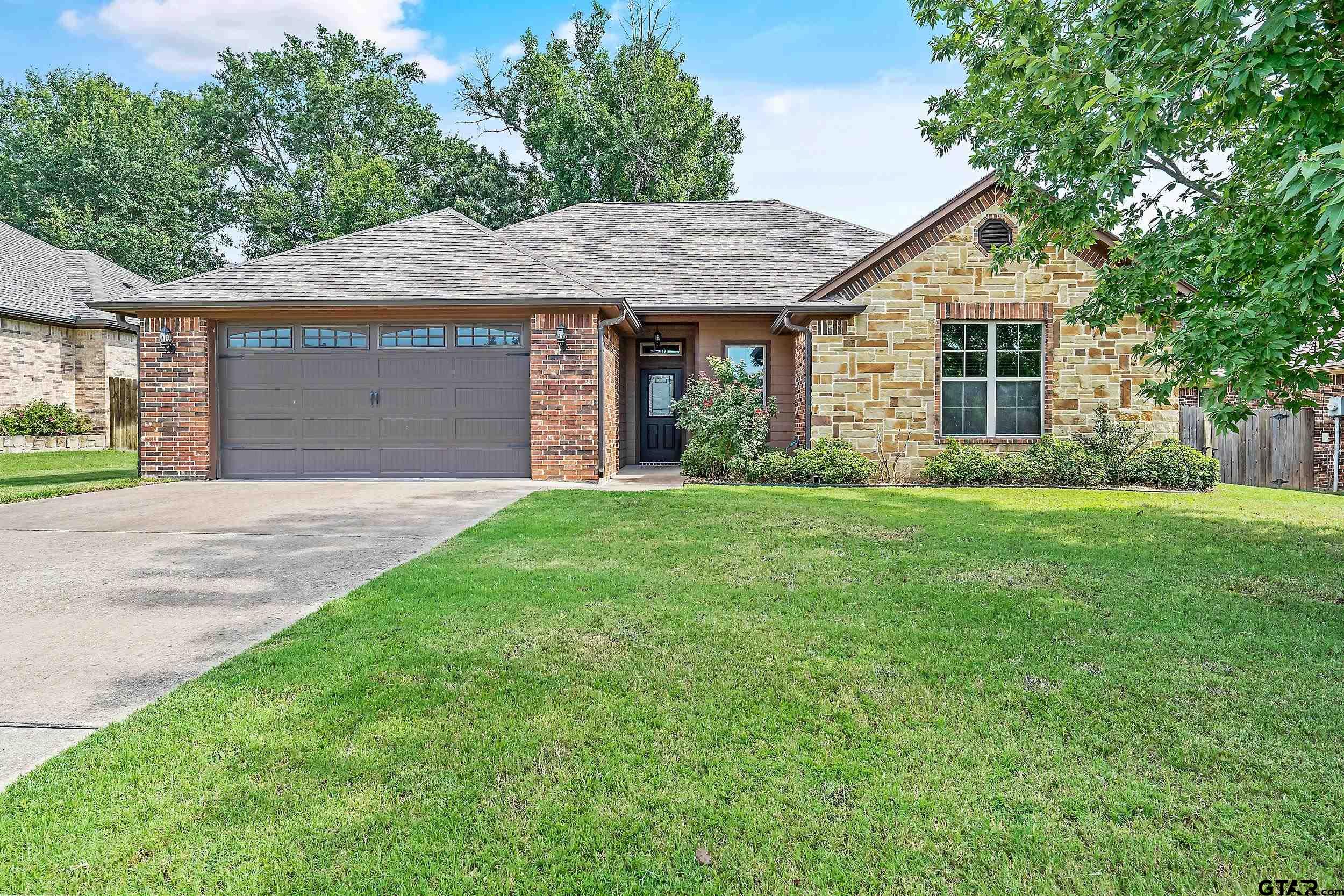 a front view of a house with a yard and garage