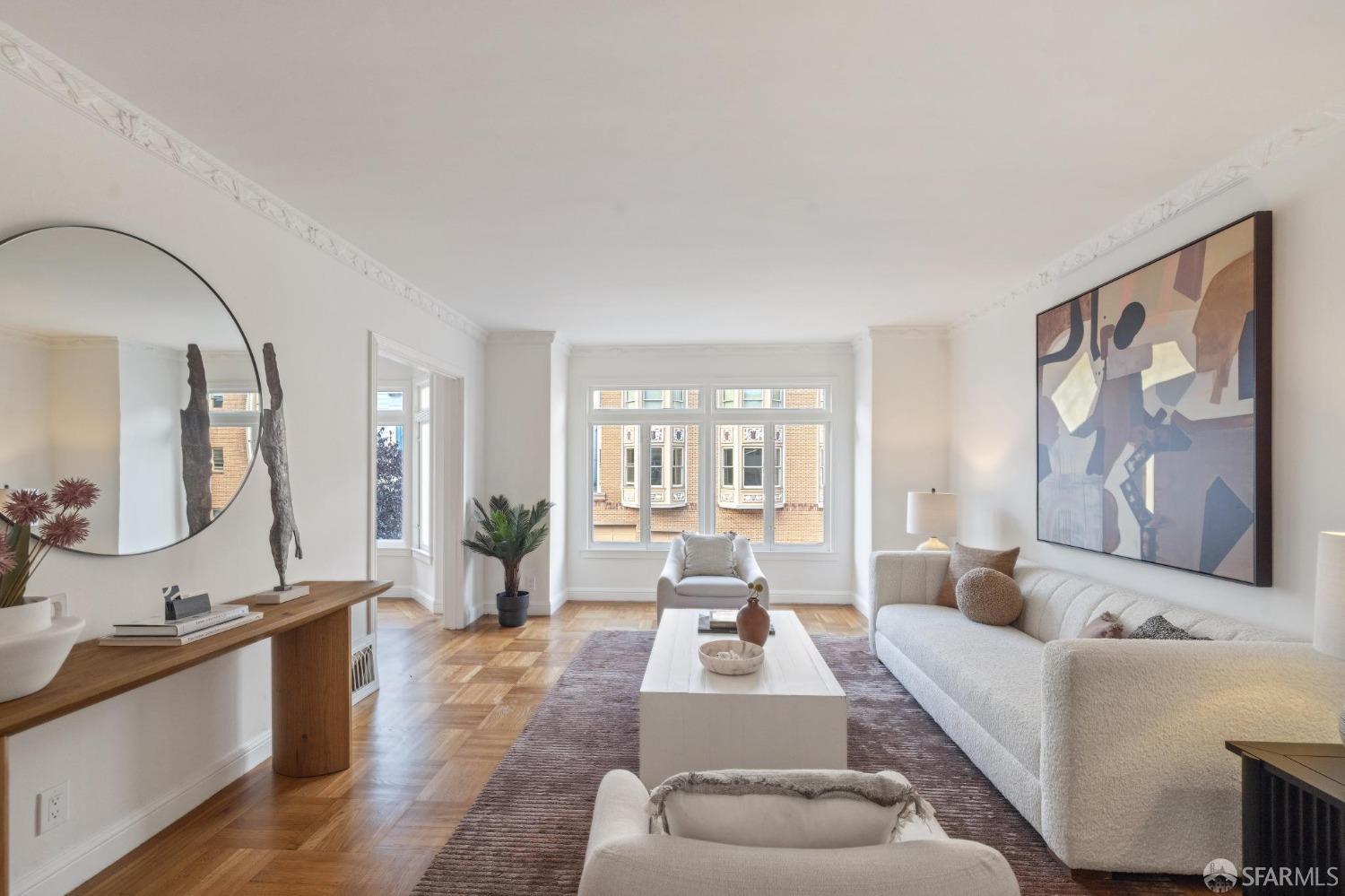 a living room with furniture and a large mirror next to a window