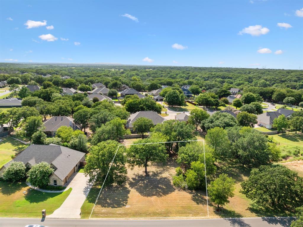 an aerial view of residential houses with outdoor space and trees