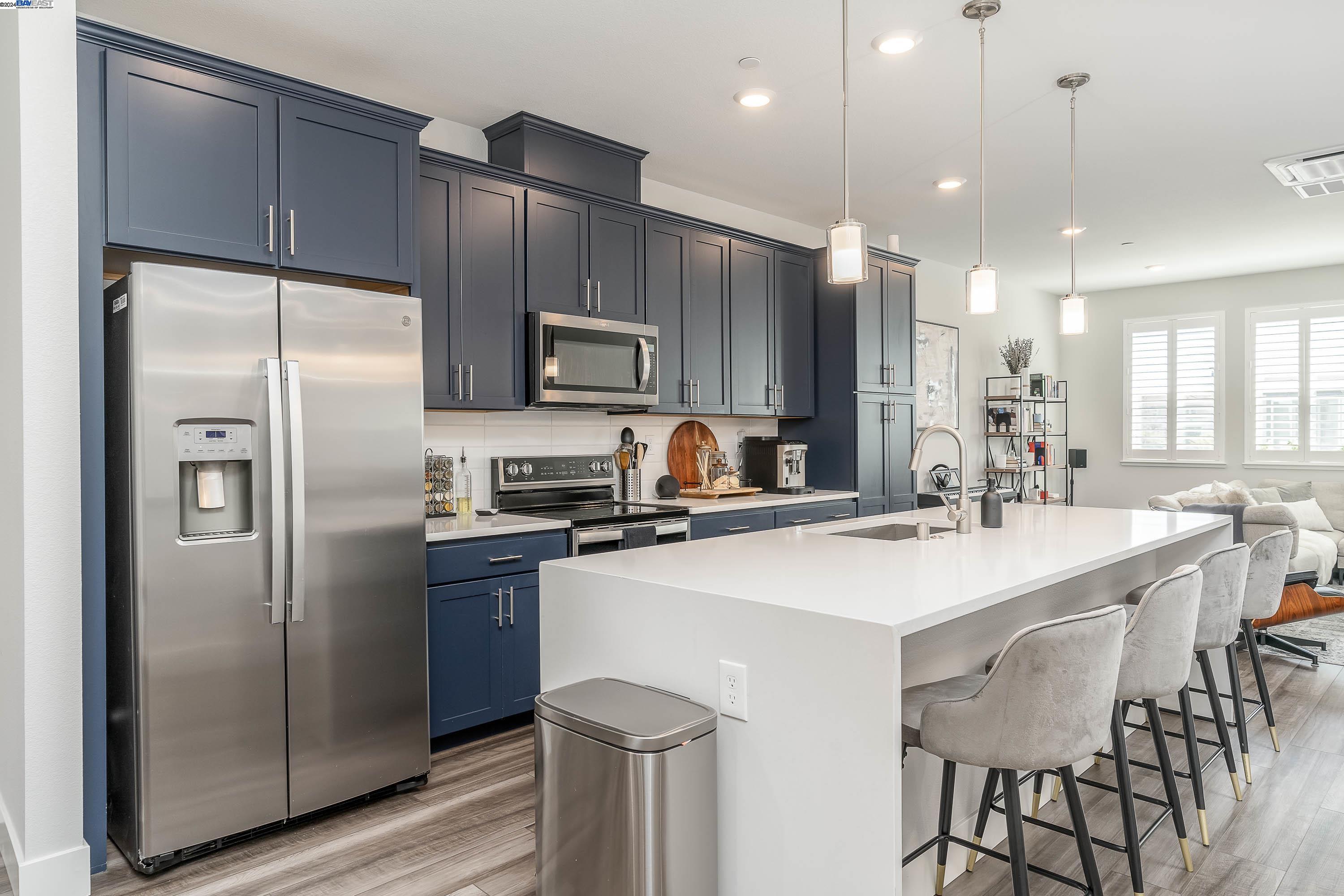 a kitchen with kitchen island a refrigerator stove microwave and cabinets