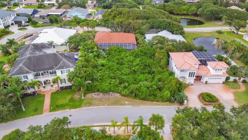 an aerial view of a house with garden space and a street view