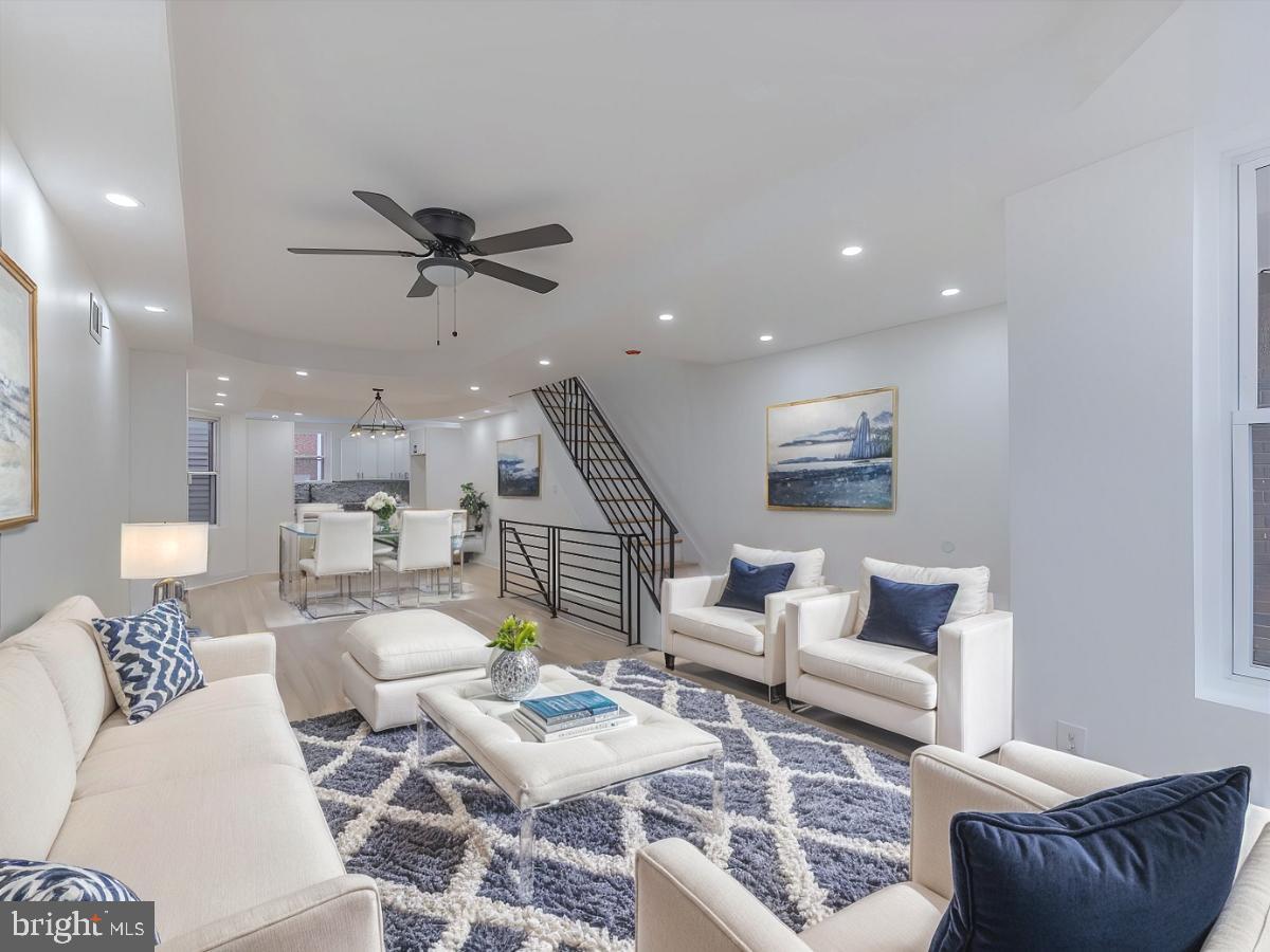 a living room with furniture and a ceiling fan