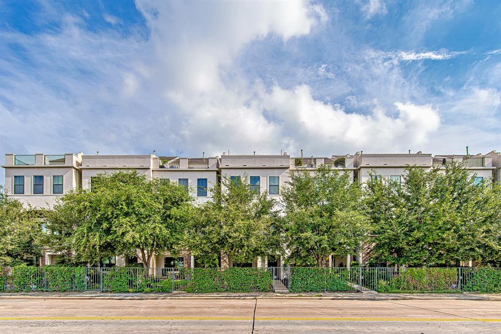 Charming home (center) nestled within a gated community, offering privacy and security, surrounded by lush greenery and tree-lined streets, creating a serene urban retreat.