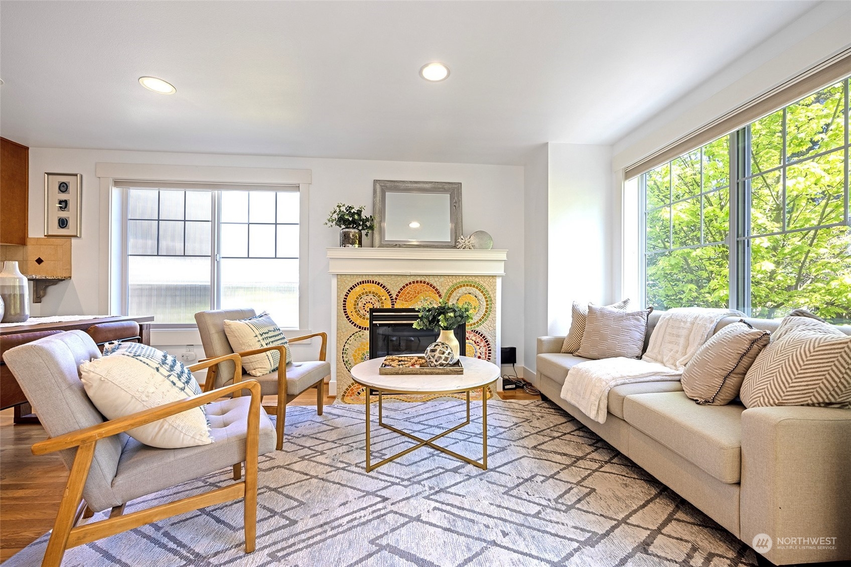 a living room with furniture a fireplace and a large window