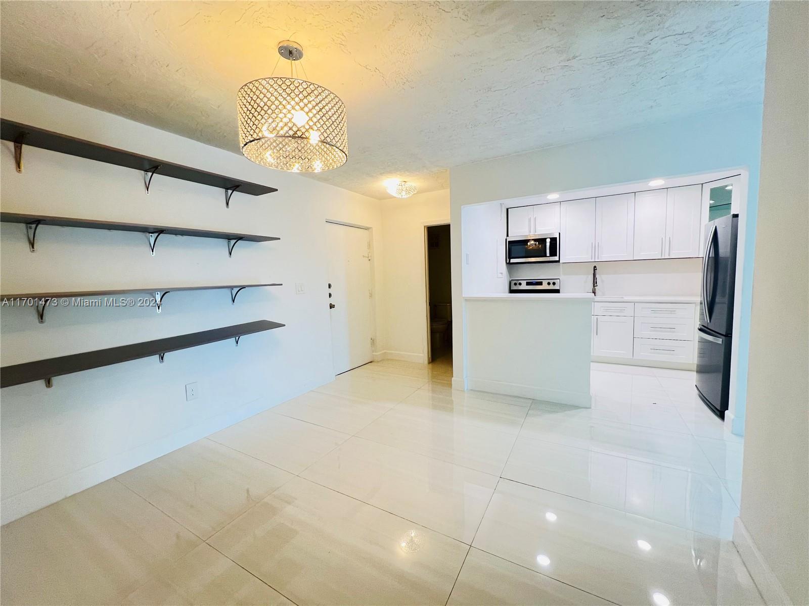 a view of a kitchen with a refrigerator a dishwasher cabinets and a dining table