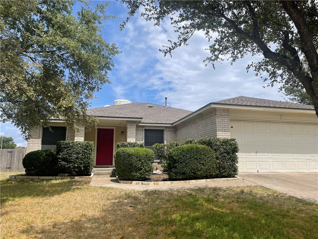 a front view of house with yard and trees around