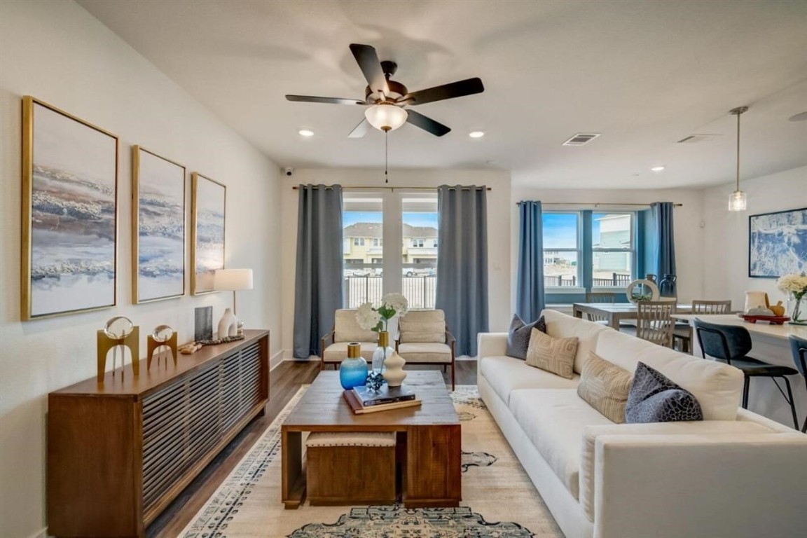 a living room with furniture and floor to ceiling windows