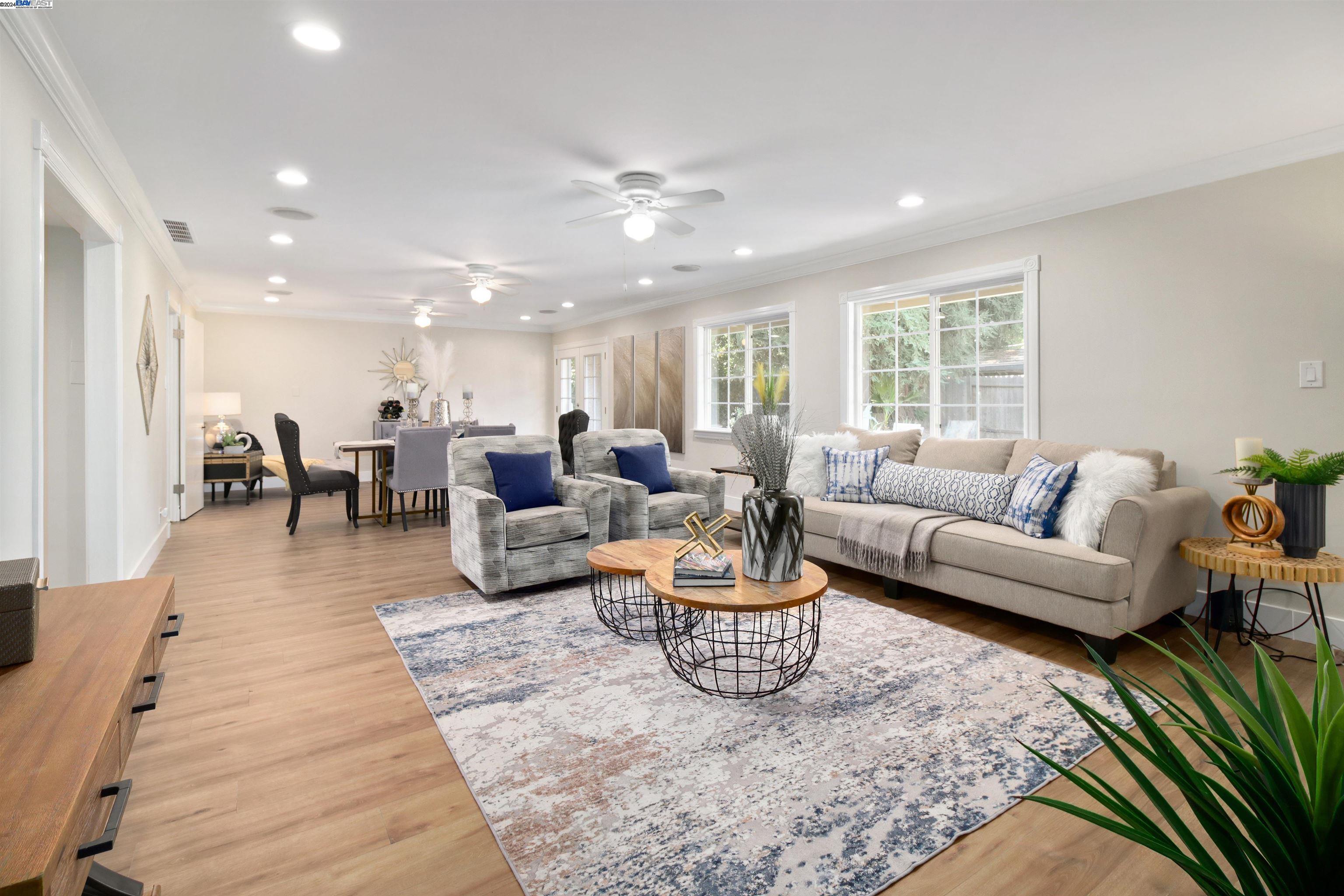 a living room with furniture kitchen view and a large window