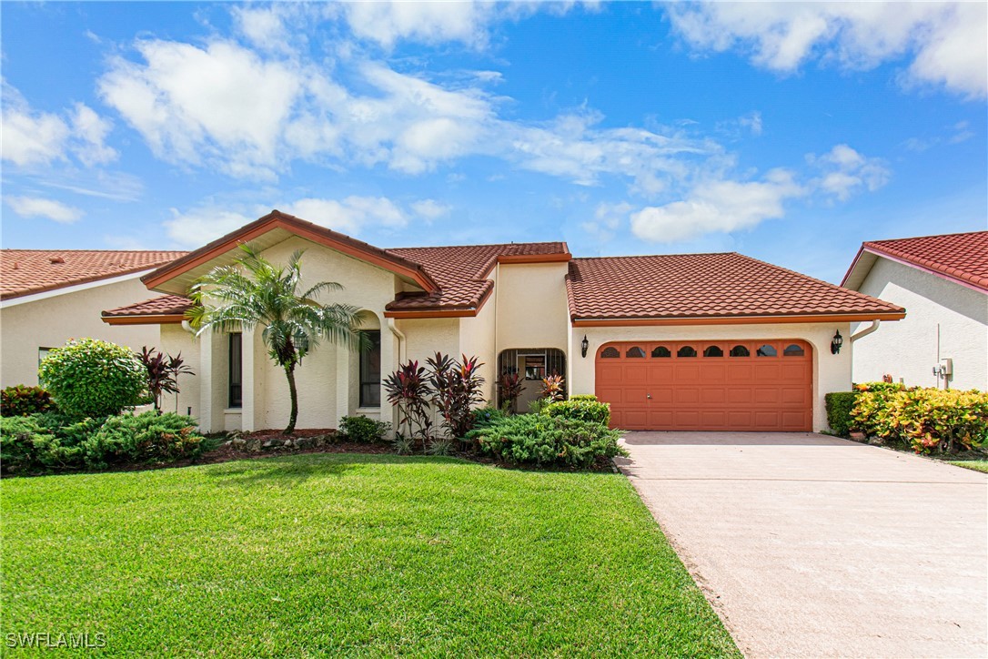 a front view of a house with a yard and trees