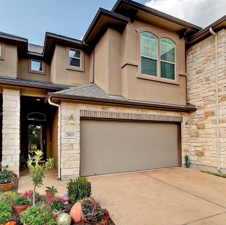 a front view of a house with a yard and garage