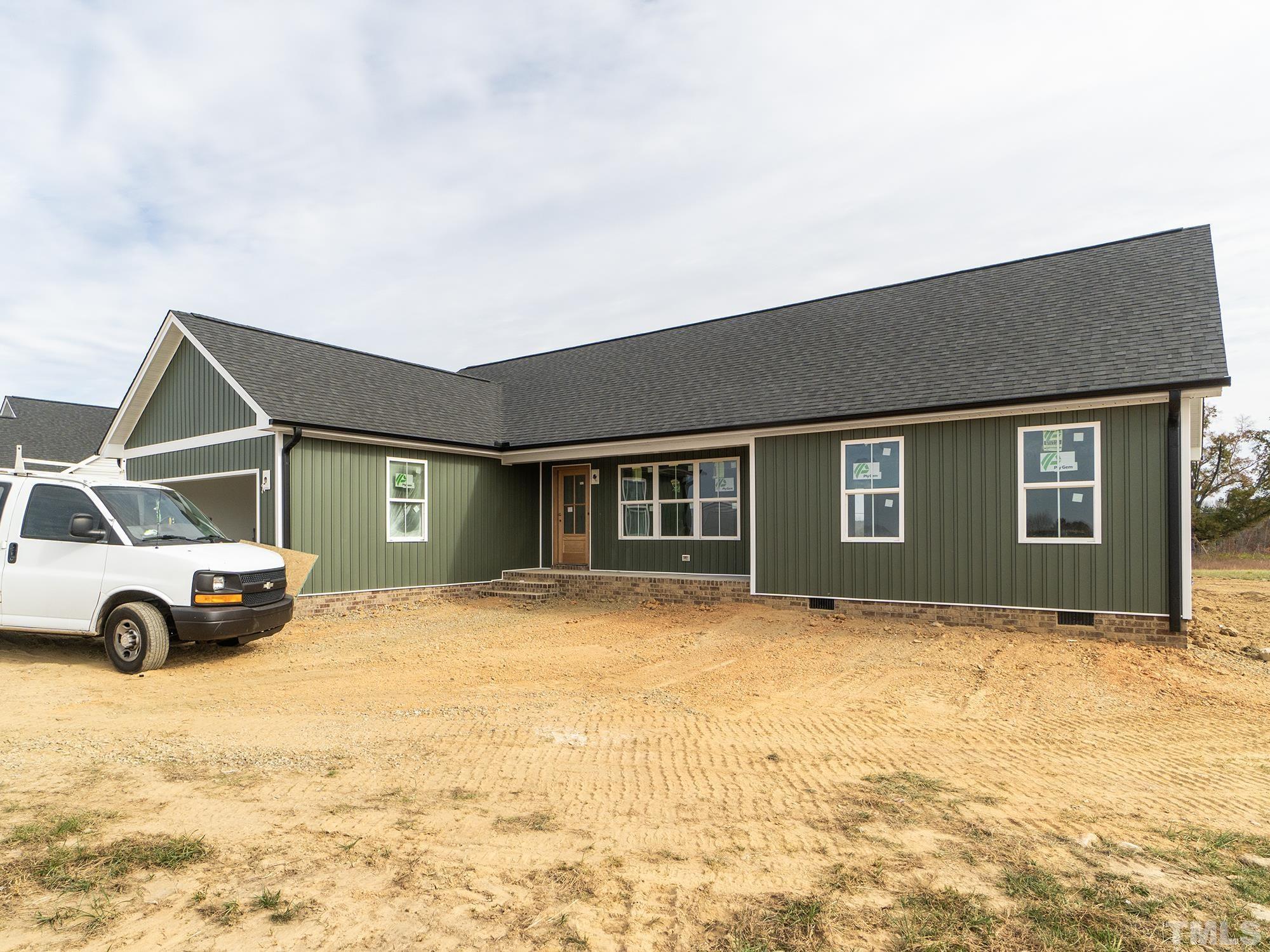 a view of an house with backyard and parking