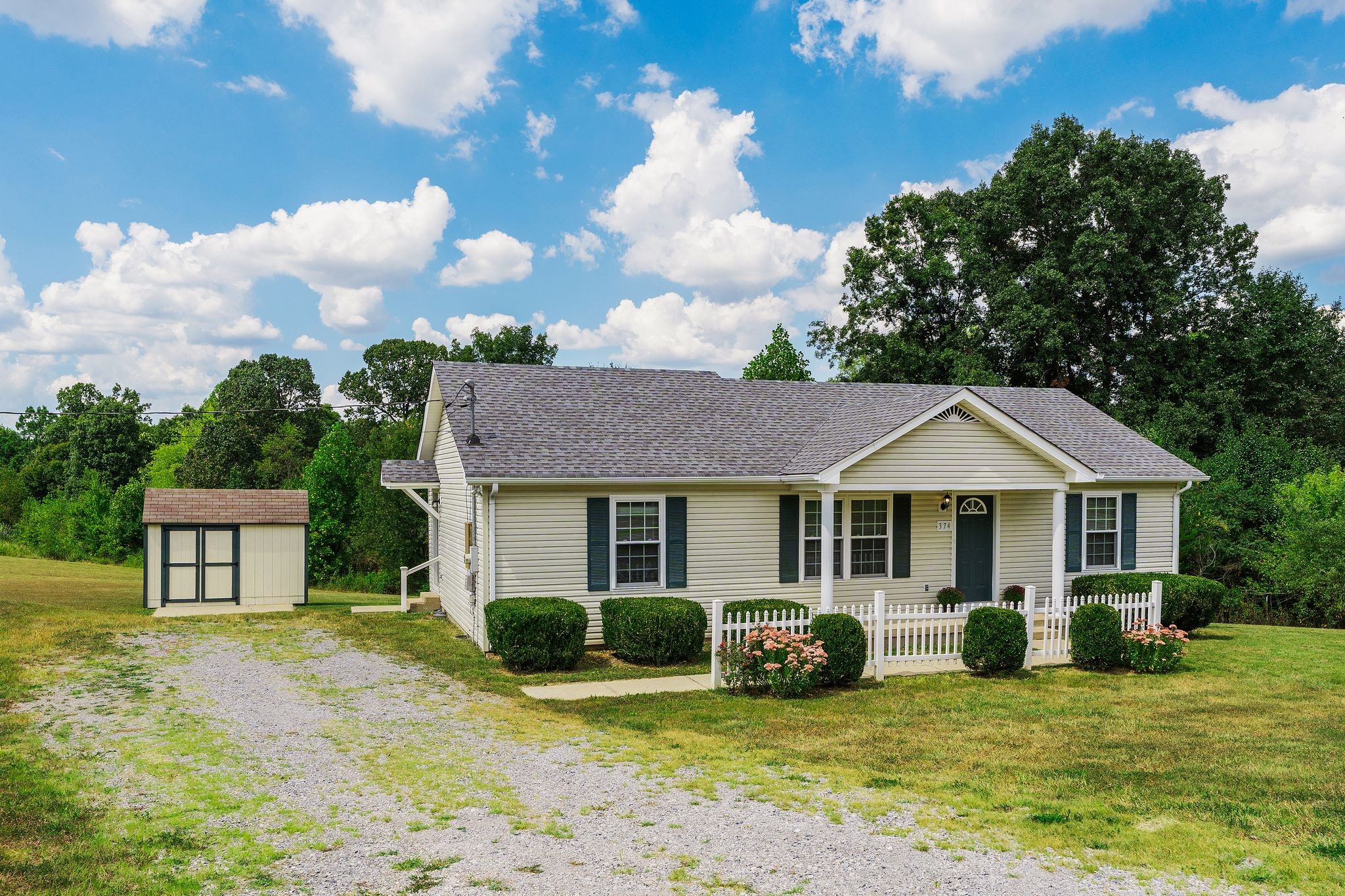 a front view of a house with a garden and yard