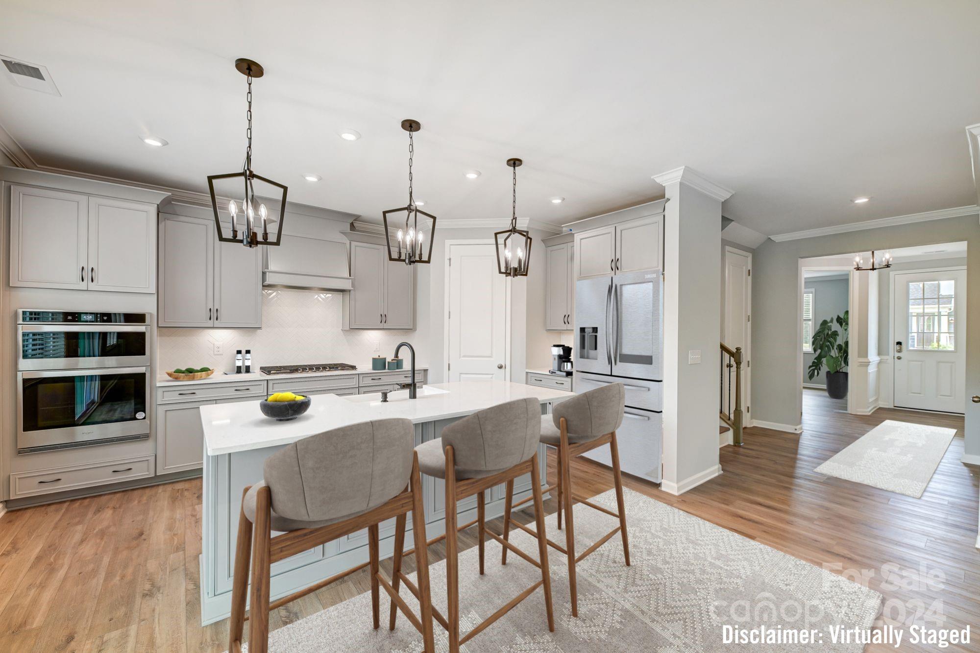 a kitchen with stainless steel appliances a dining table chairs stove and cabinets