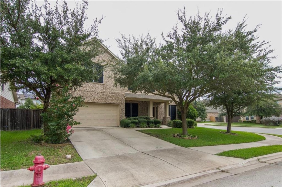 a front view of a house with a yard and tree s