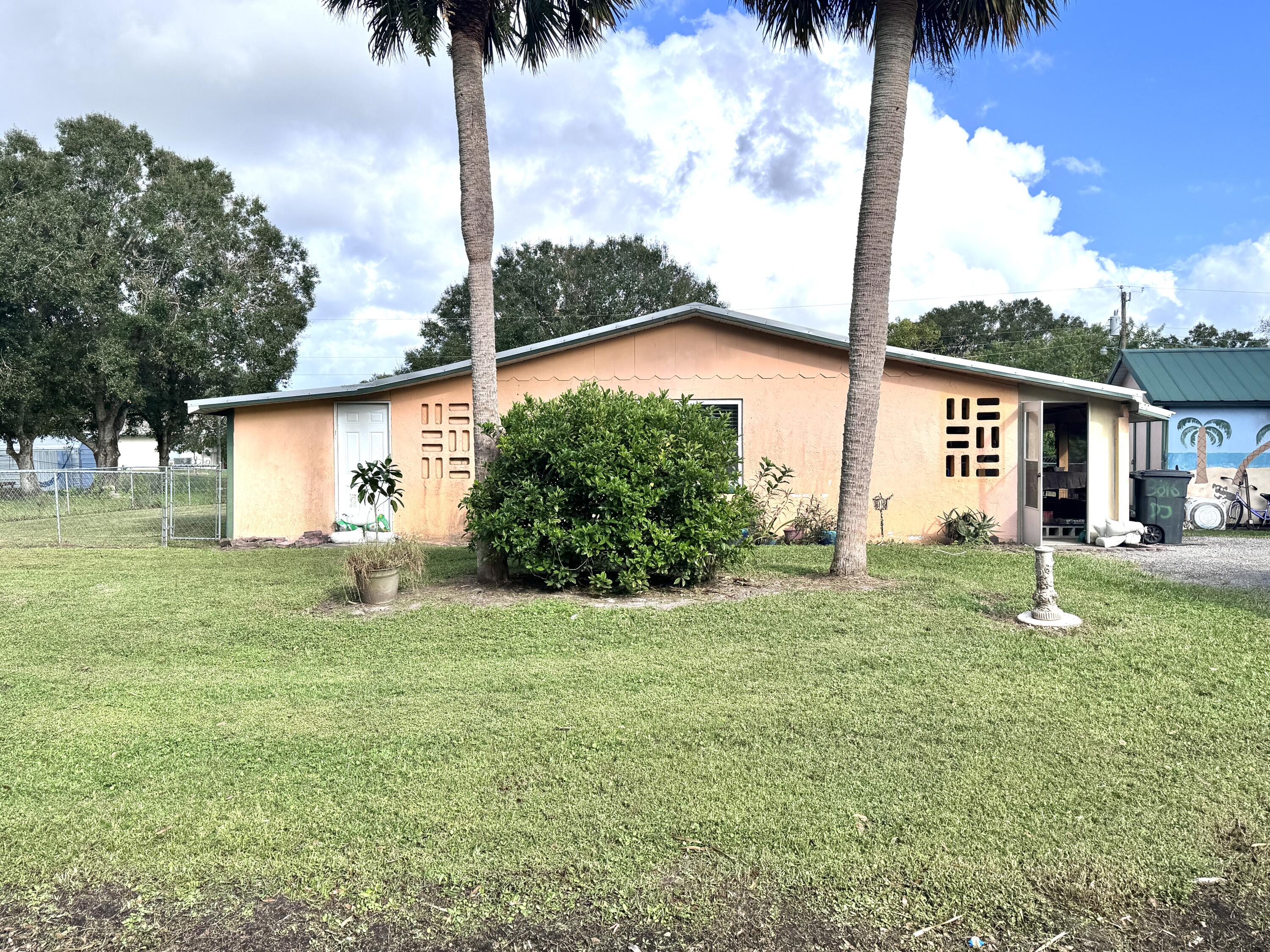 a view of a house with backyard and a tree