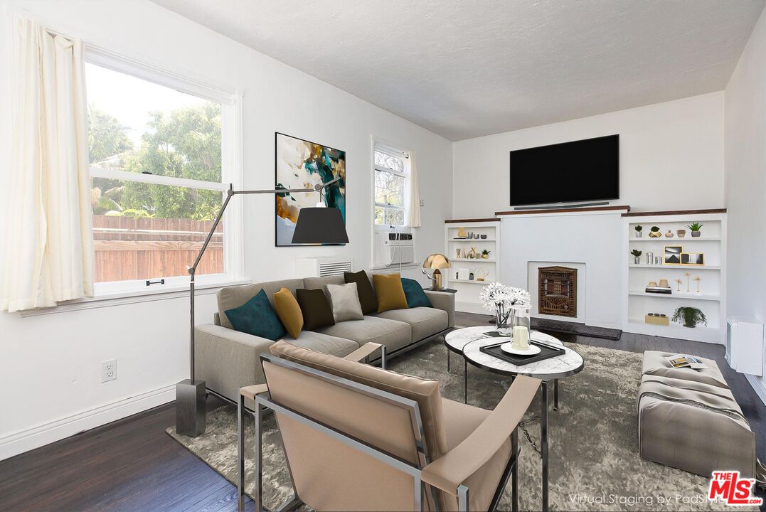 a living room with furniture a flat screen tv and a fireplace