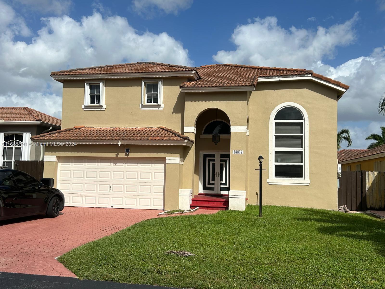 a front view of a house with a garden