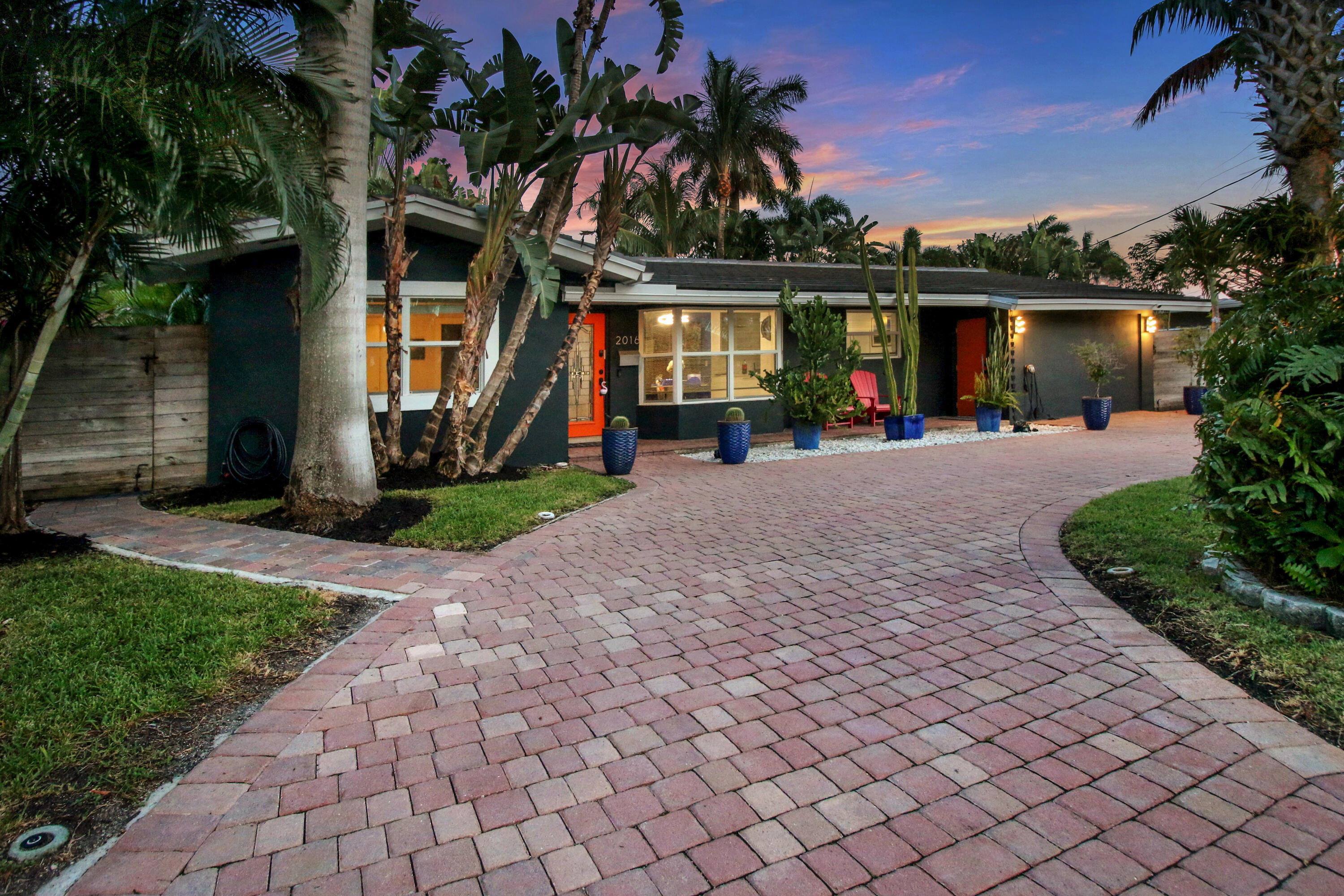 front view of a house with a yard and a garden