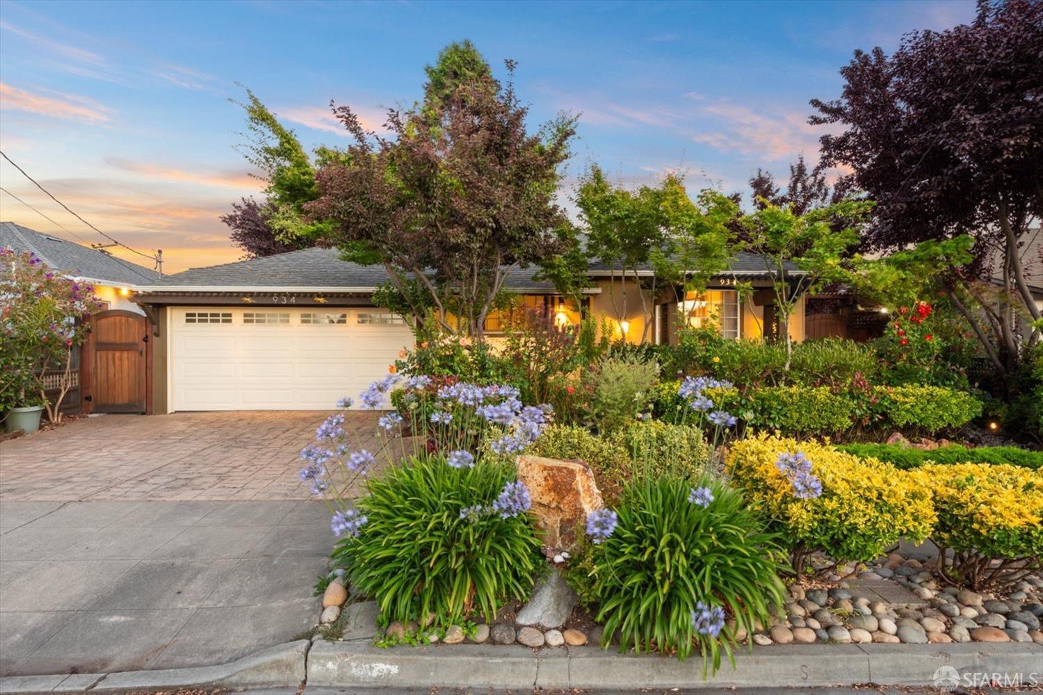 a front view of a house with a yard and potted plants