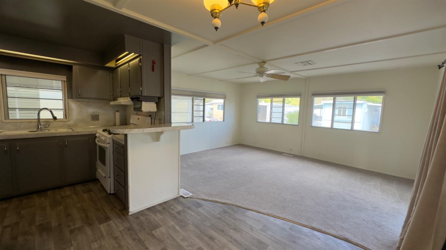 a view of a kitchen with a sink dishwasher a fireplace with wooden floor