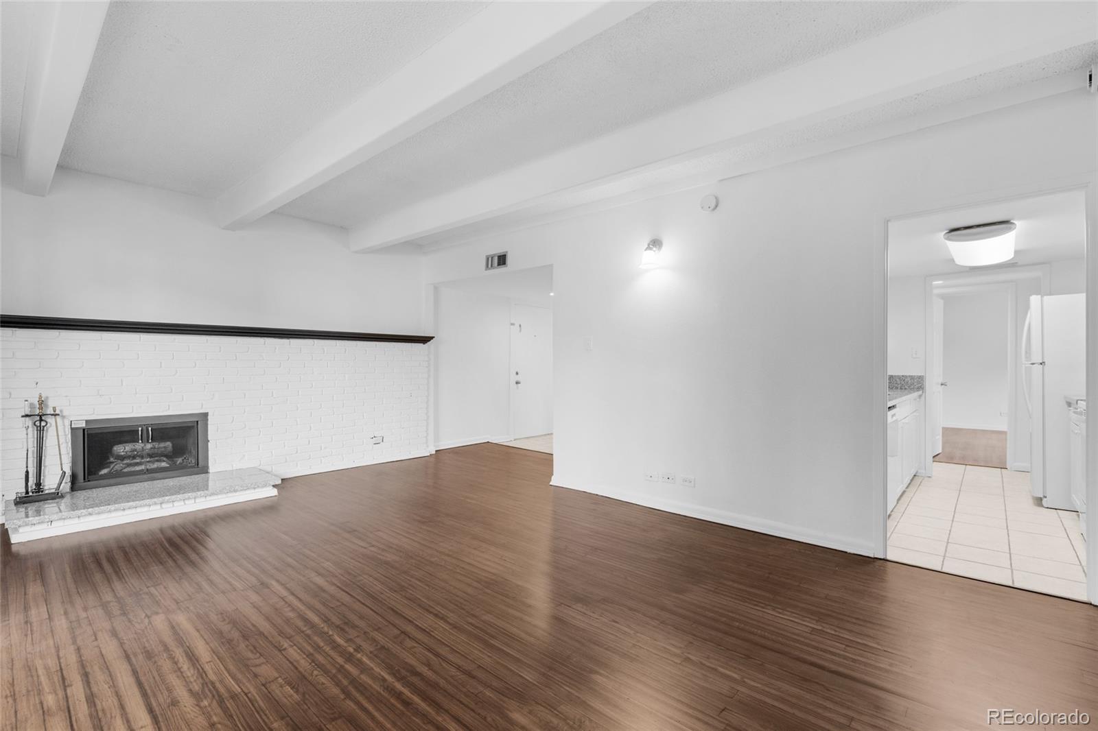 an empty room with wooden floor and fireplace