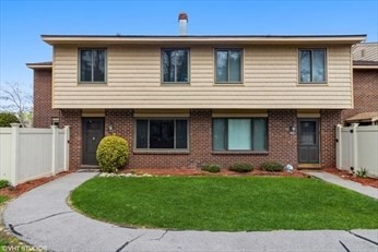 a front view of a house with a garden and yard