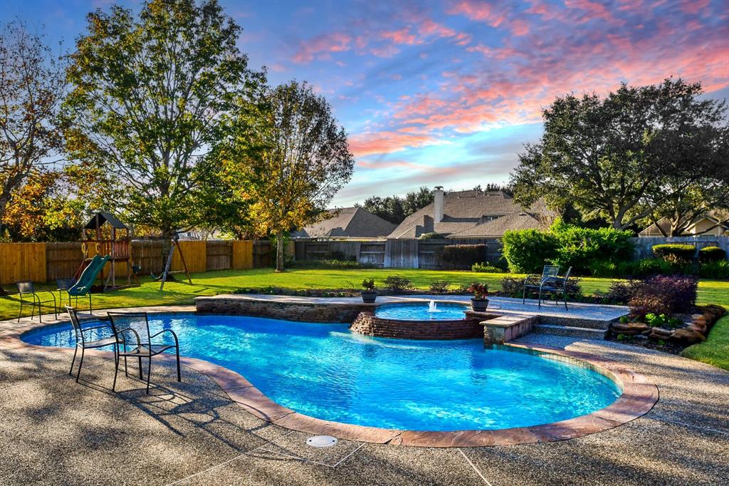 a view of a swimming pool with lounge chairs in back yard