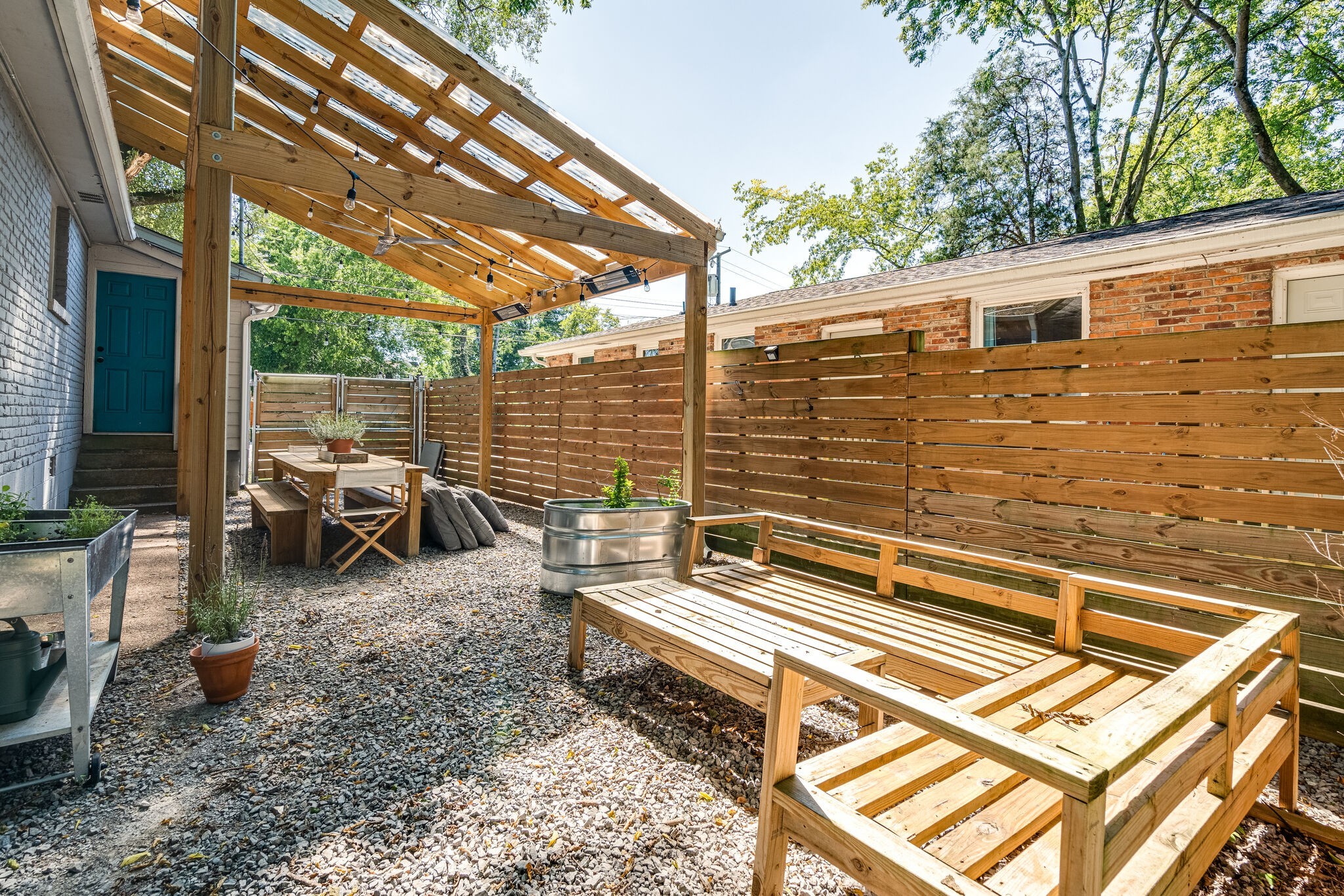 a backyard of a house with barbeque oven table and chairs