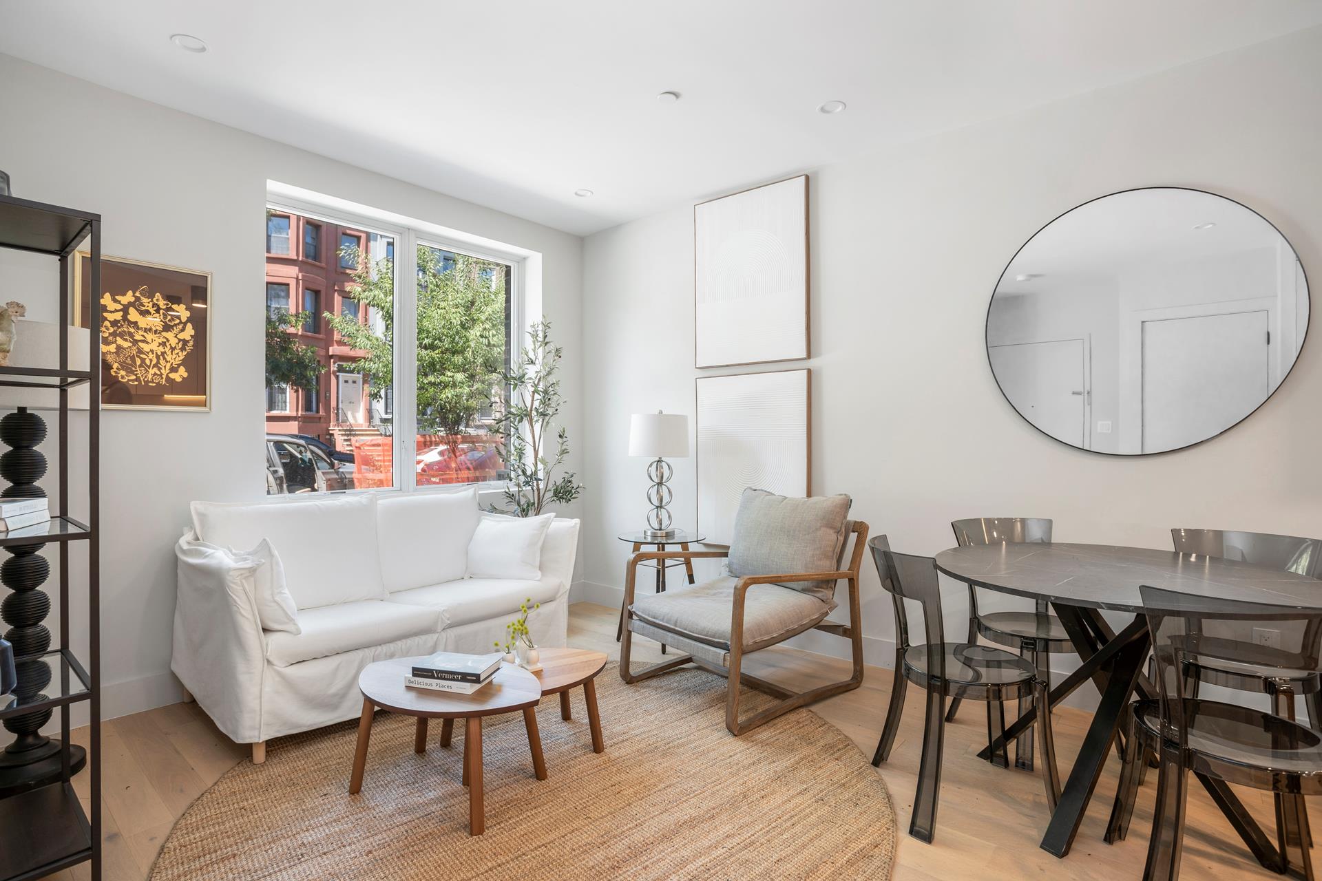 a living room with furniture a rug potted plant and a large window