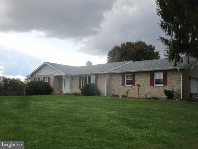 a front view of a house with a yard and trees