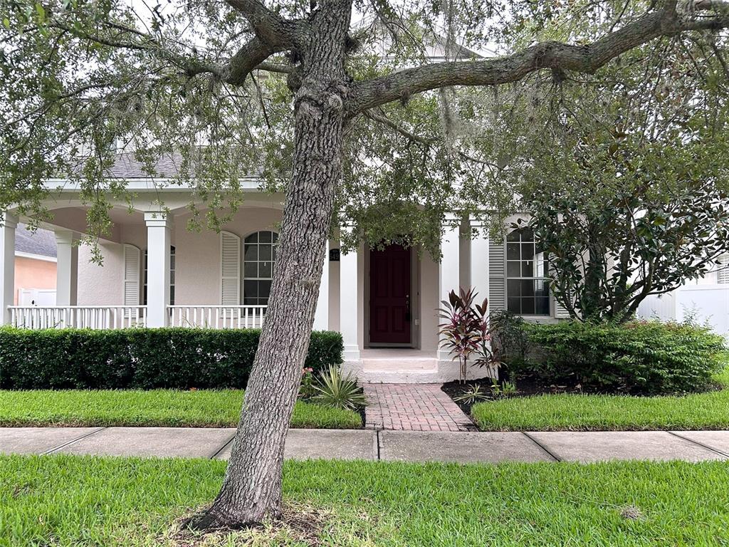 a front view of a house with a yard and potted plants