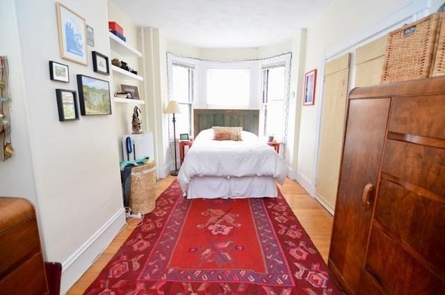 a bed sitting in a bedroom next to a window