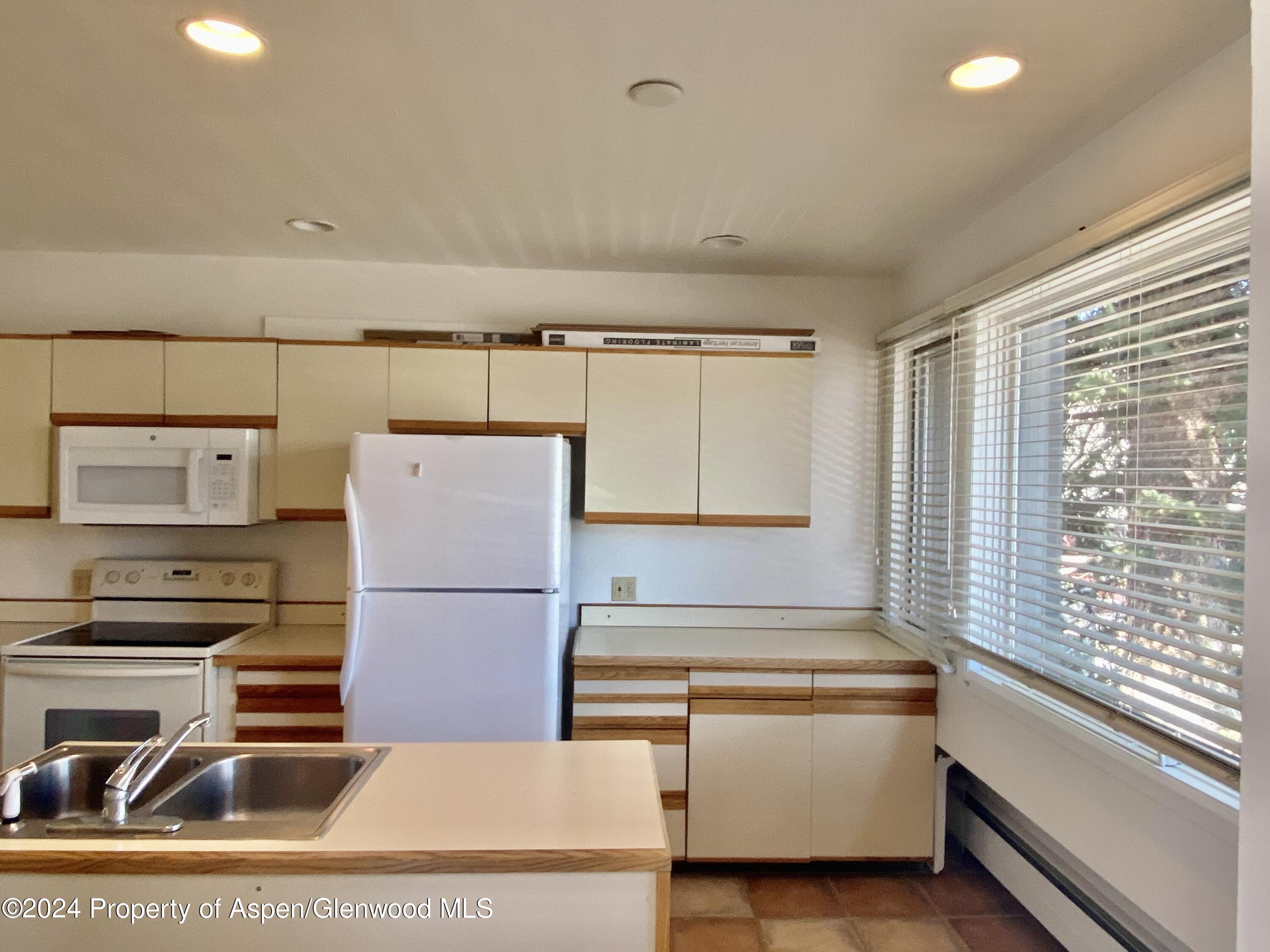 a kitchen with a refrigerator and a stove top oven