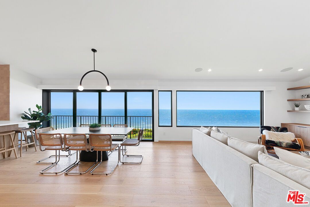 a living room with furniture a rug and a floor to ceiling window