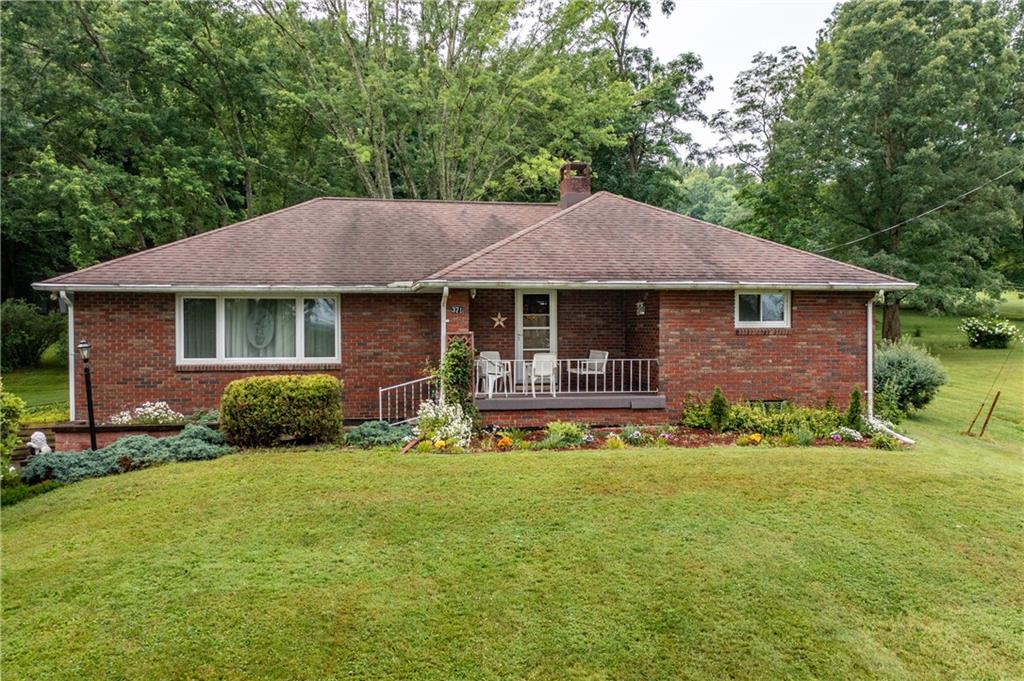 a front view of a house with a garden and trees