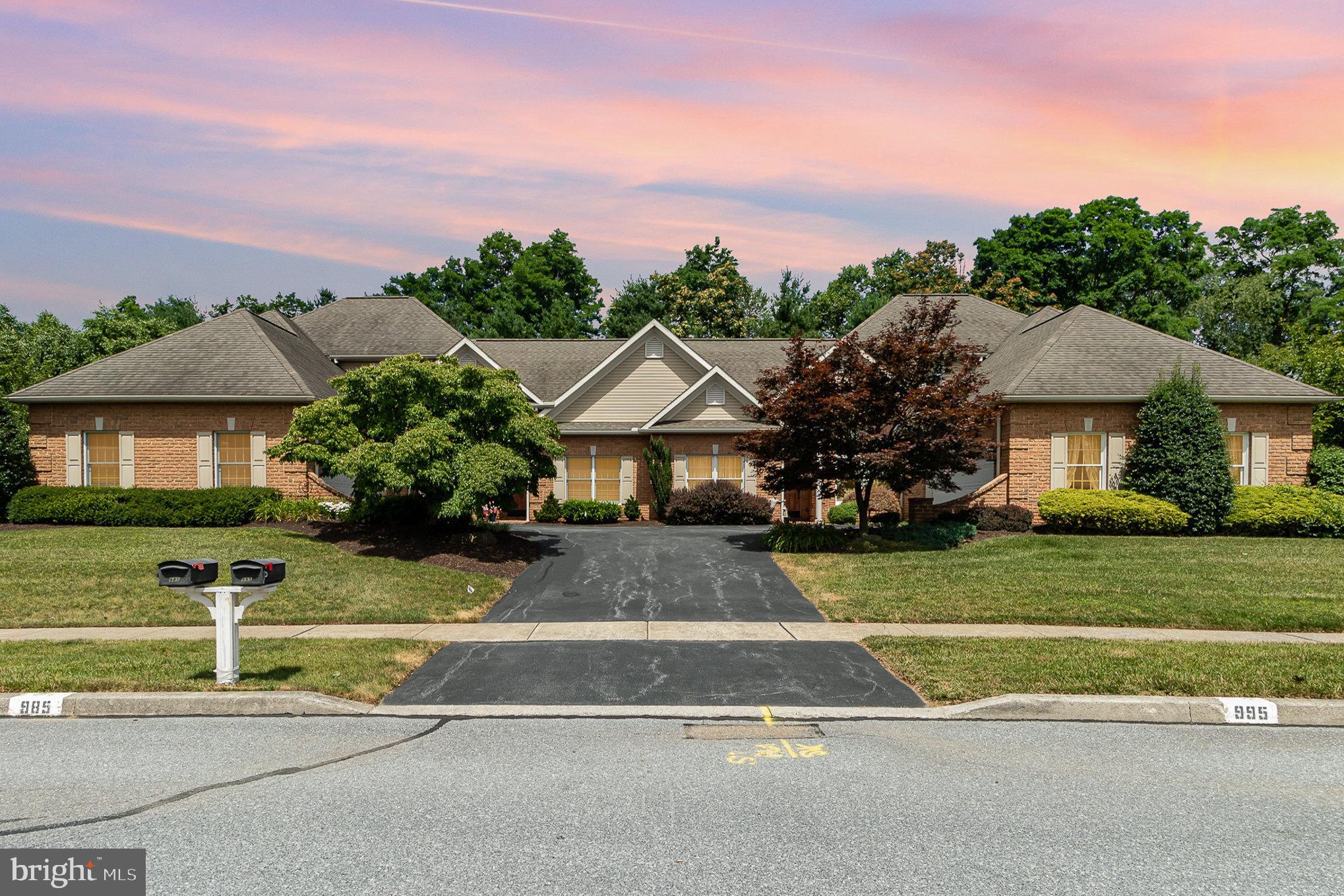 a front view of a house with a yard and trees