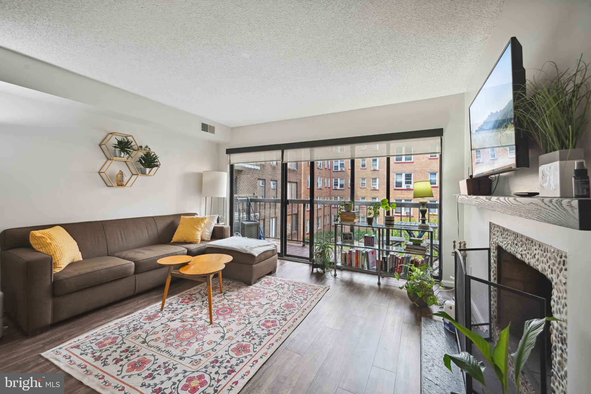 a living room with furniture a flat screen tv and a floor to ceiling window