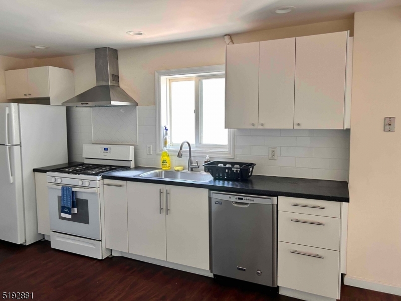 a kitchen with granite countertop a sink cabinets and stainless steel appliances