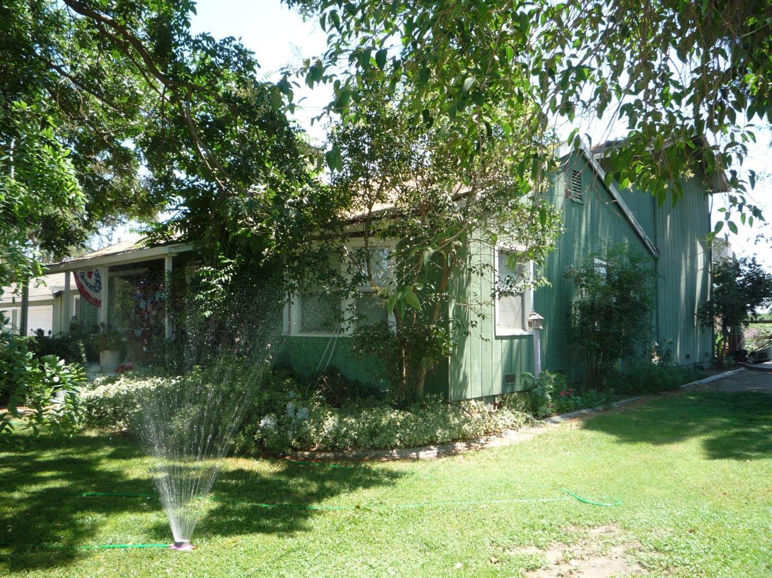 a backyard of a house with lots of green space and fountain