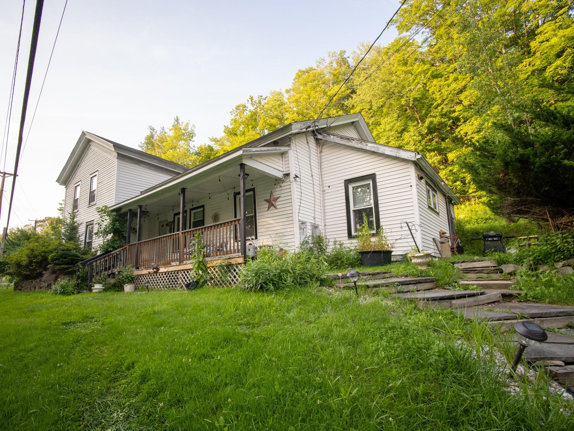 Back of property featuring covered porch and a yard