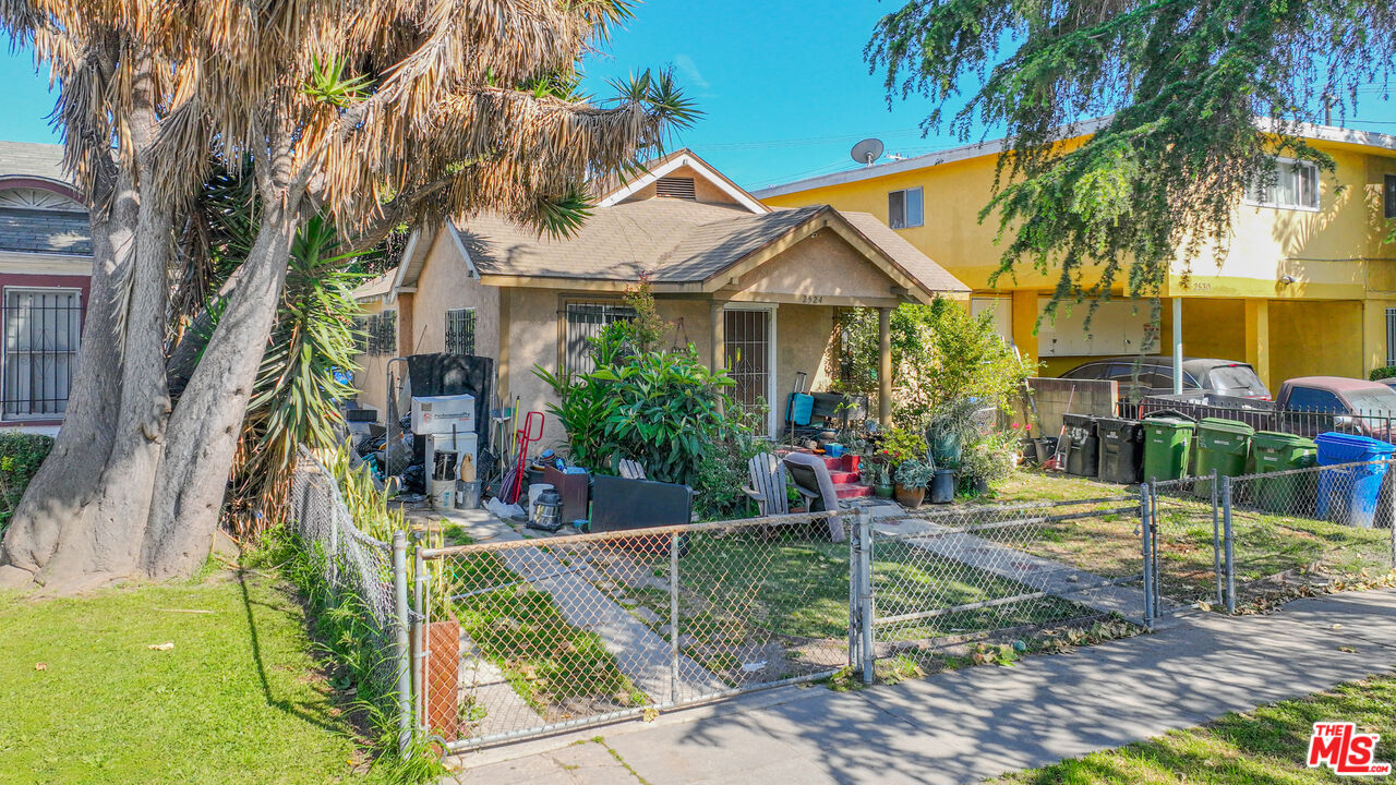 a view of a house with a yard and potted plants