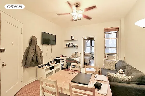 a living room with furniture a flat screen tv and a window