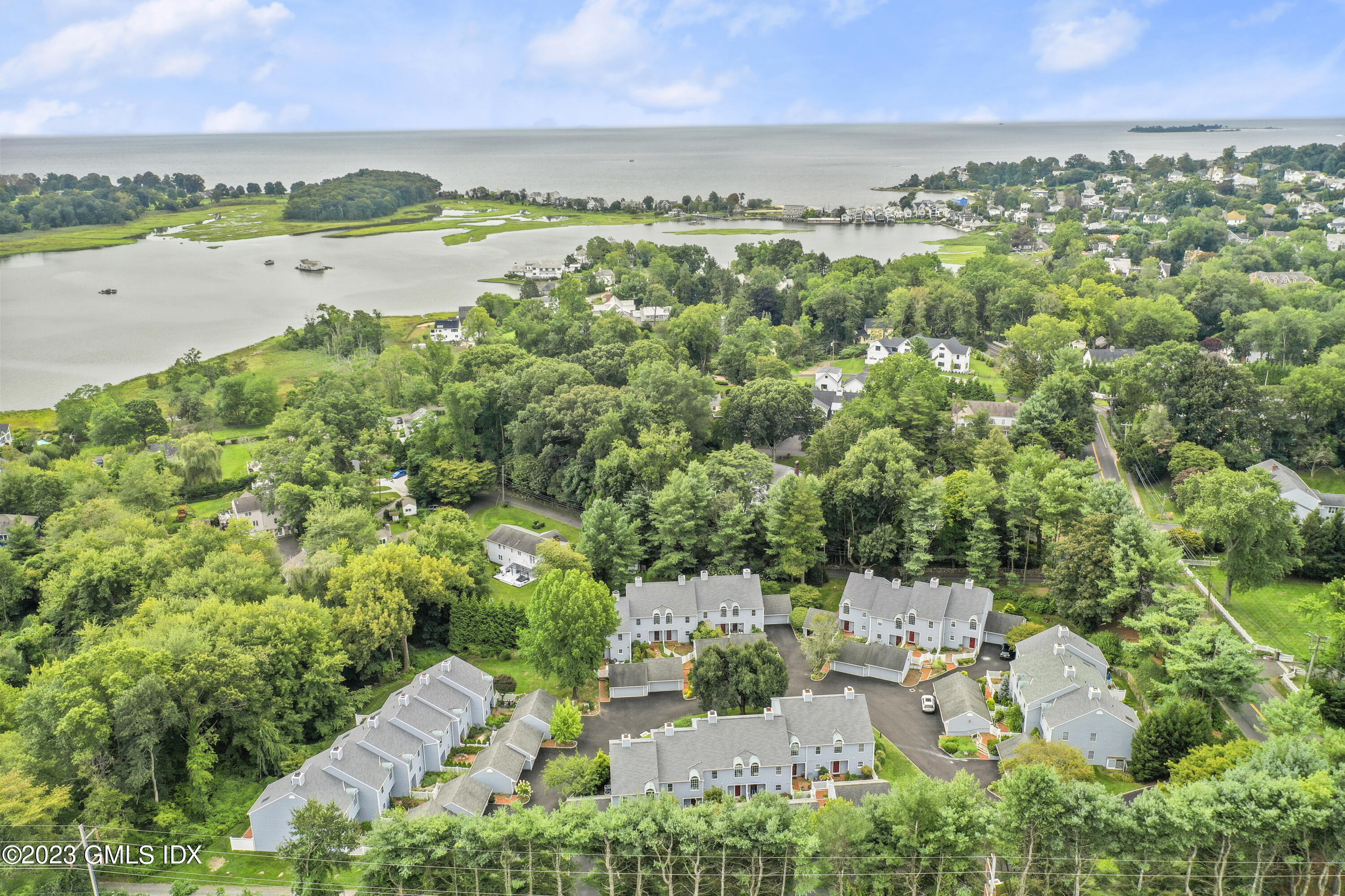 an aerial view of a city with lots of residential buildings ocean and mountain view in back