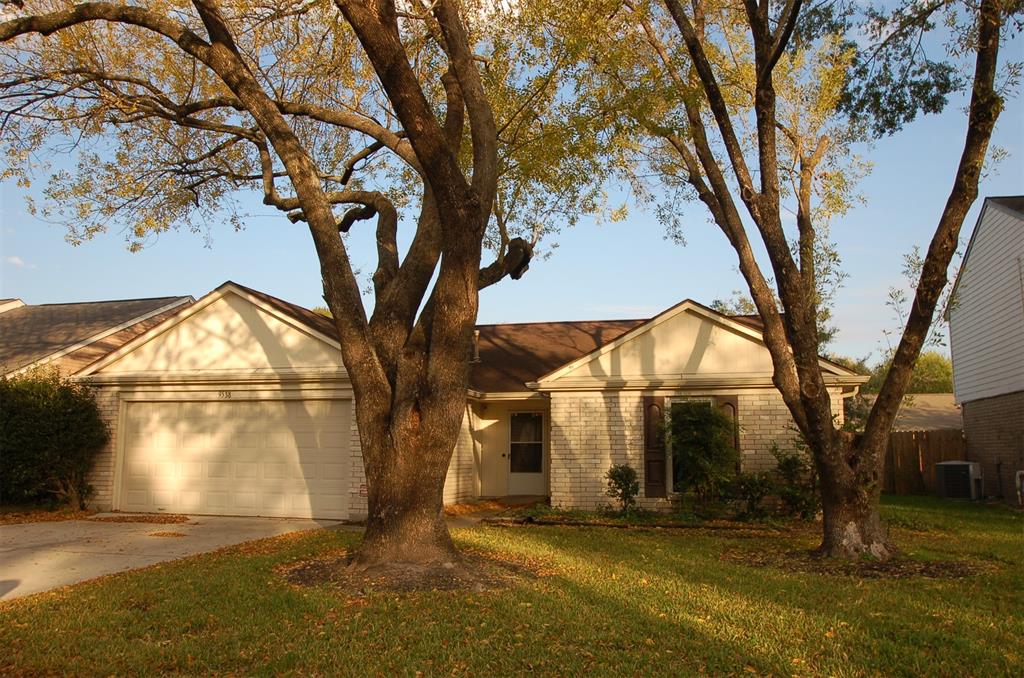 a view of a house with a large tree and a yard