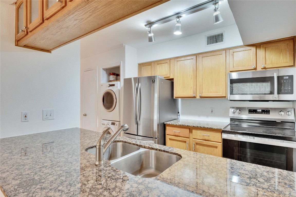 a kitchen with a sink cabinets and stainless steel appliances