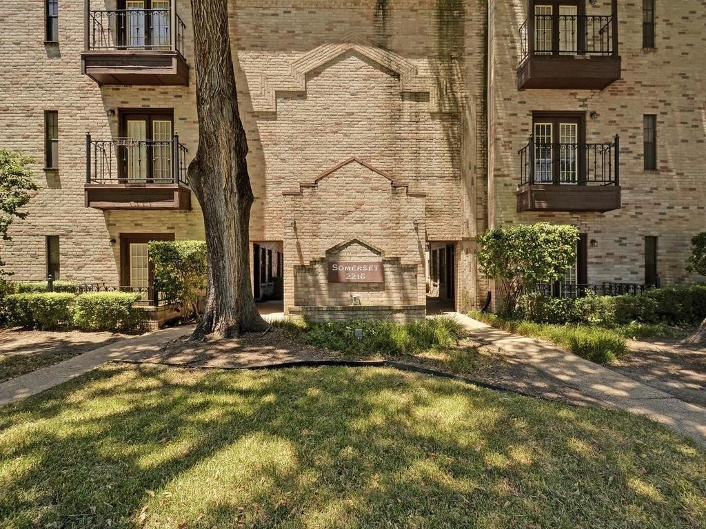 front view of a brick house with a yard