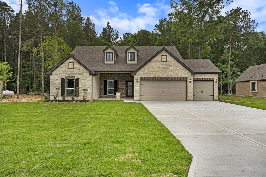 a front view of a house with a garden and yard