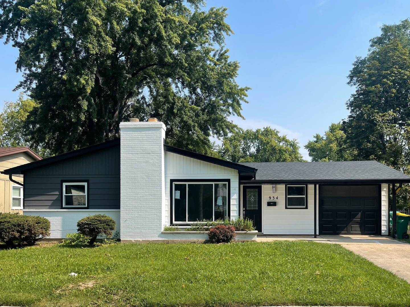 a front view of a house with a yard and trees