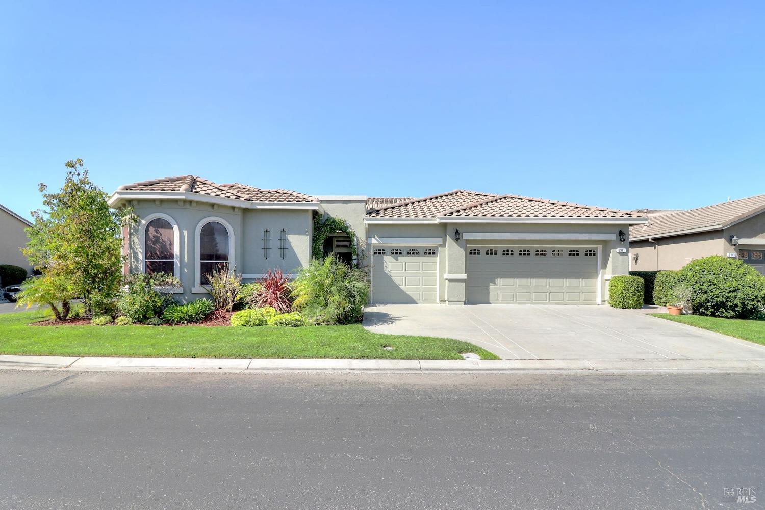 a front view of a house with a garden and yard